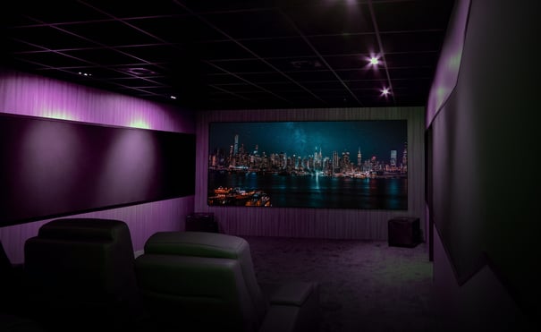 Dedicated home cinema room with purple ambient lighting