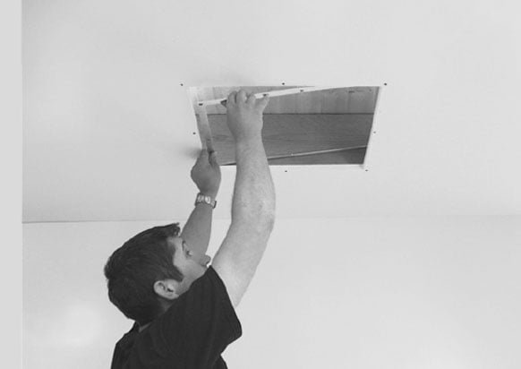 man installing ceiling recessed projector lift